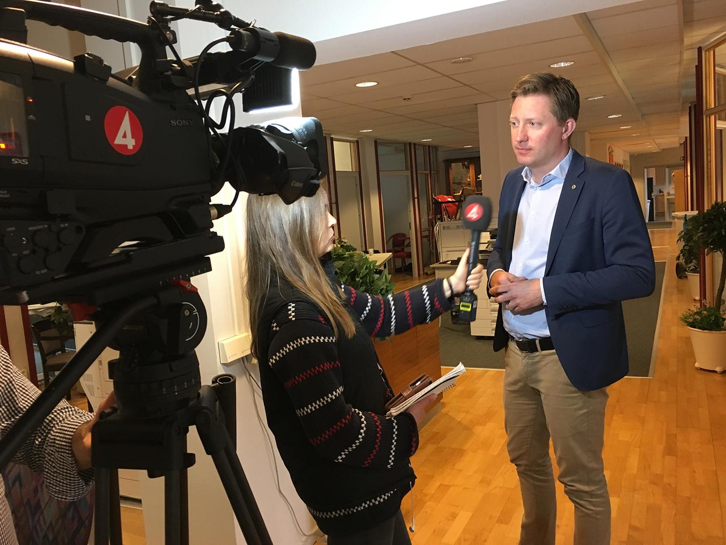 Journalist och HRFs förbundsordförande står framför filmkamera med TV4-märke.