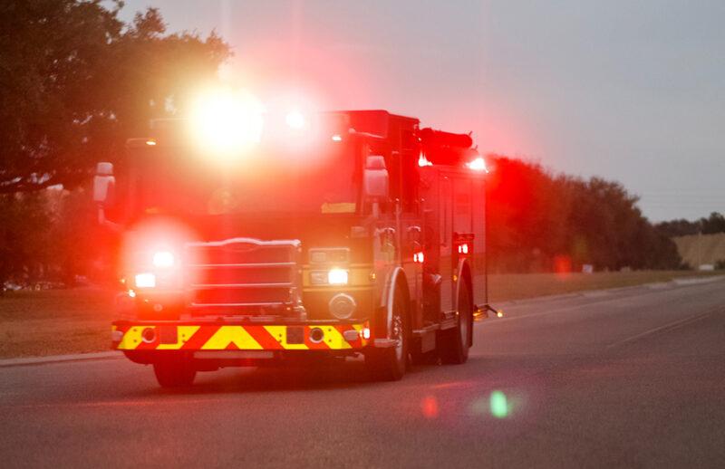 brandbil med lysande strålkastare på landsväg.