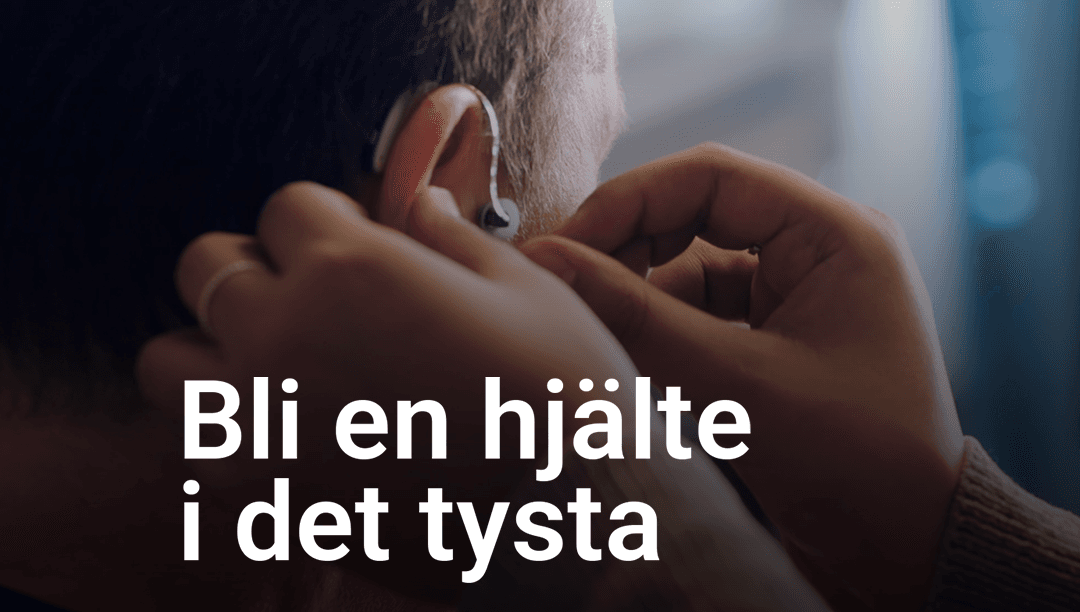 Händer sätter på en hörapparat på ett öra. Text: Bli en hjälte i det tysta.