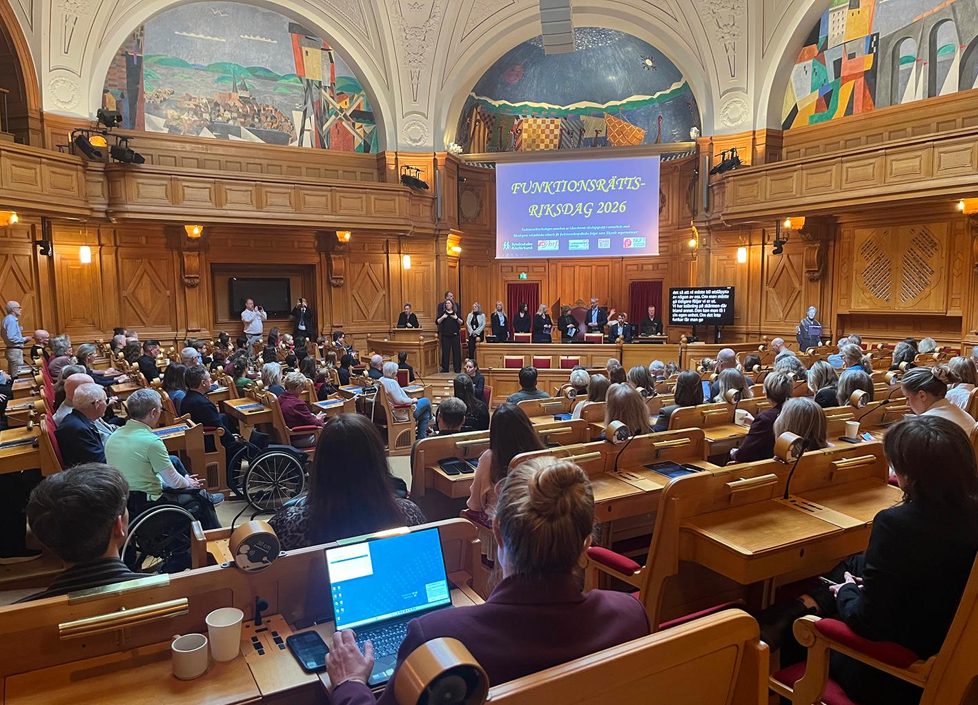 Översikt över fullsatt sal med powerpointbild där det står "Funktionsrättsriksdagen".