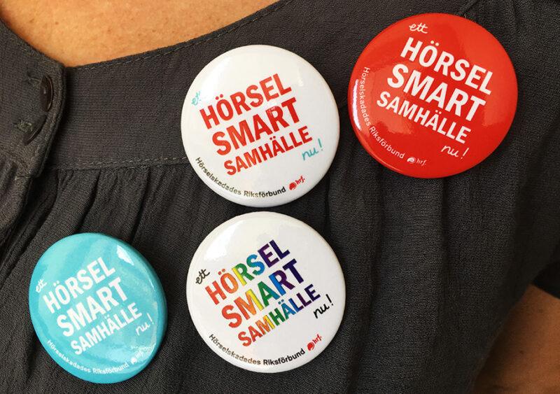 Knappar med texten: "Ett hörselsmart samhälle nu!"