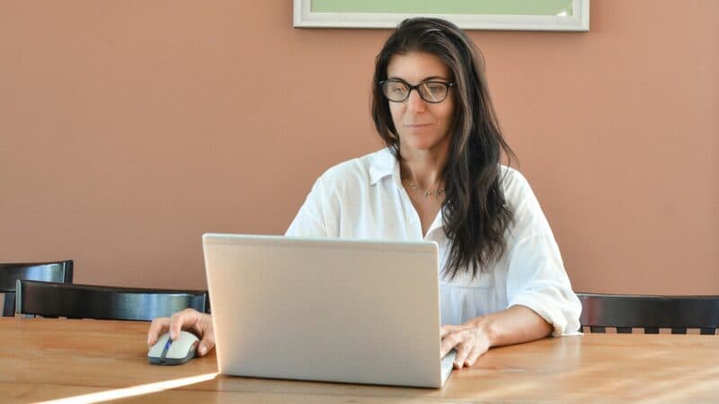 Kvinna sitter med sin laptop