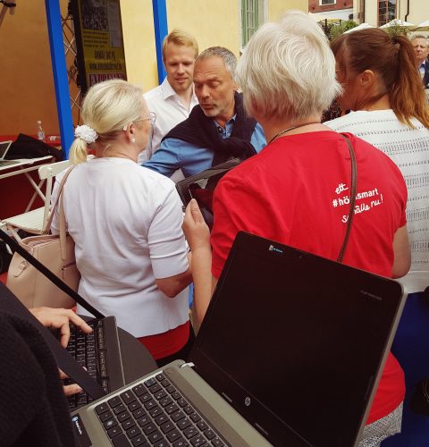 Jan Björklund med personer i HRF-tröjor. I förgrunden syns tangentbord.