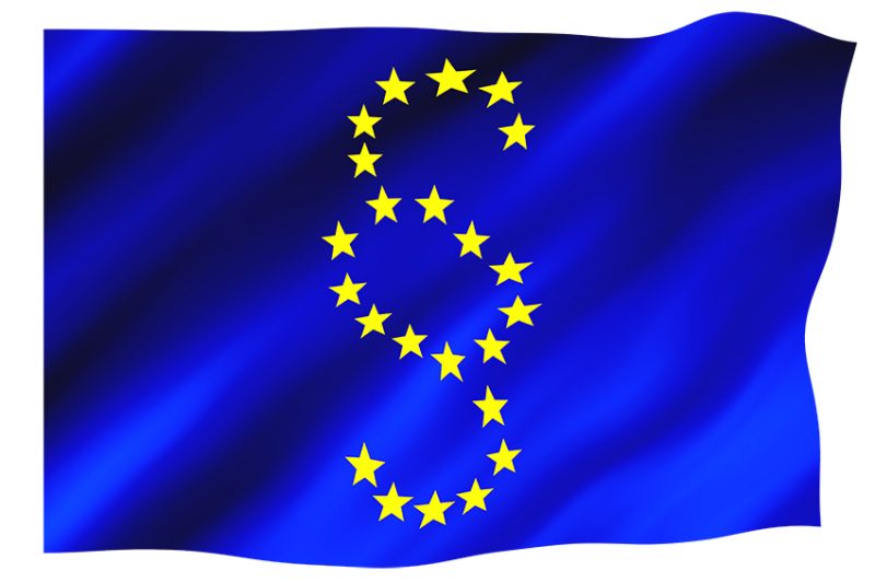 EU-flagga med gula stjärnor formade som paragraf på blått tyg.