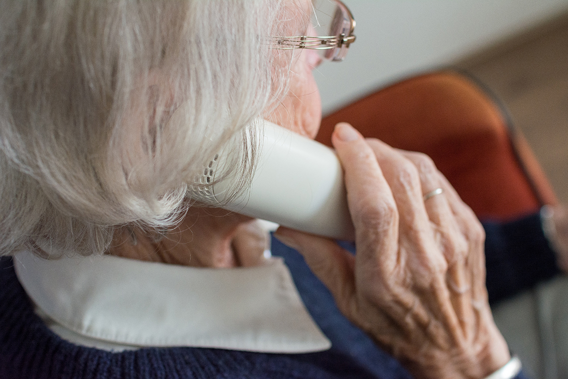 Äldre kvinna med telefonlur.
