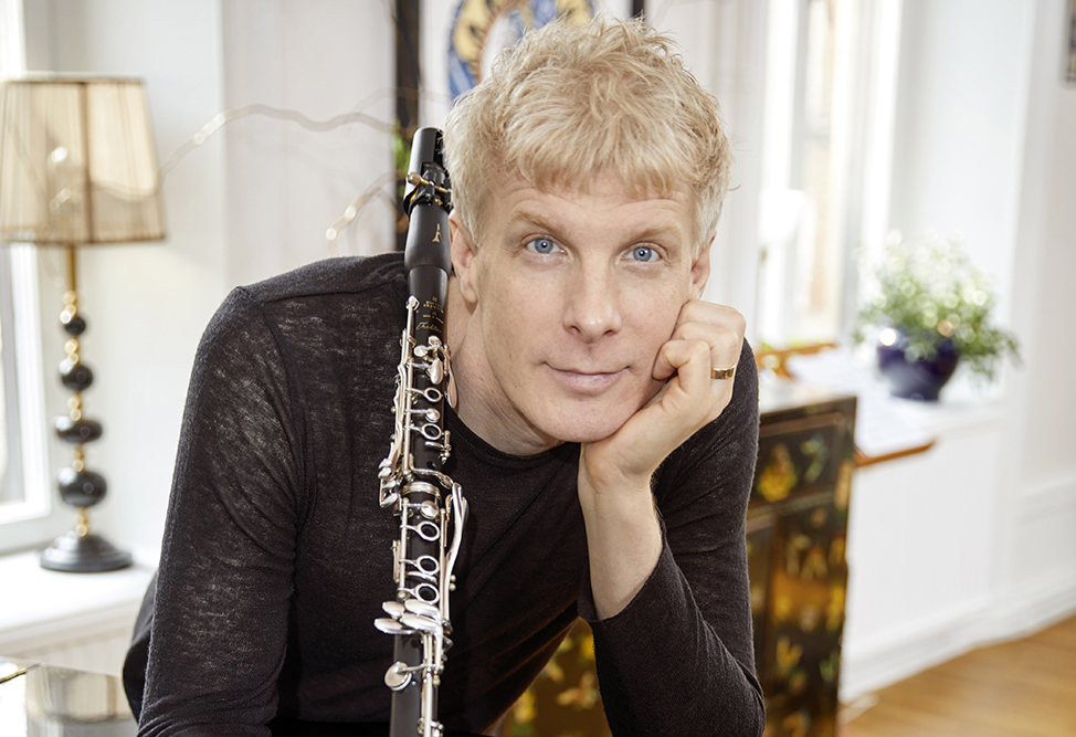 Porträtt på Martin Fröst, som ser in i kameran och håller i sin klarinett.
