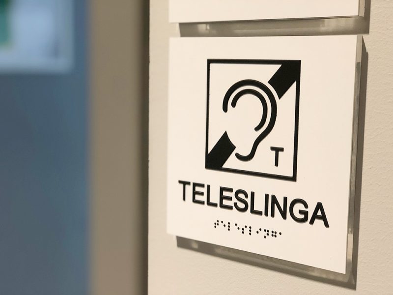 Skylt med texten TELESLINGA och internationella symbolen för teleslinga - ett öra med ett streck genom och ett T.