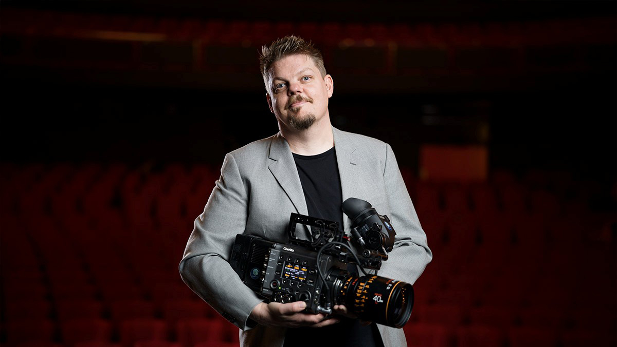 man med filmkamra i famnen.