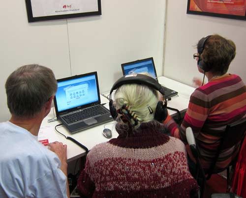 Människor sitter och tittar på en dator.