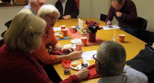 Några personer sitter och pratar och dricker glögg.