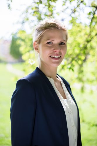 Bild på Sara, med grönska bakom.