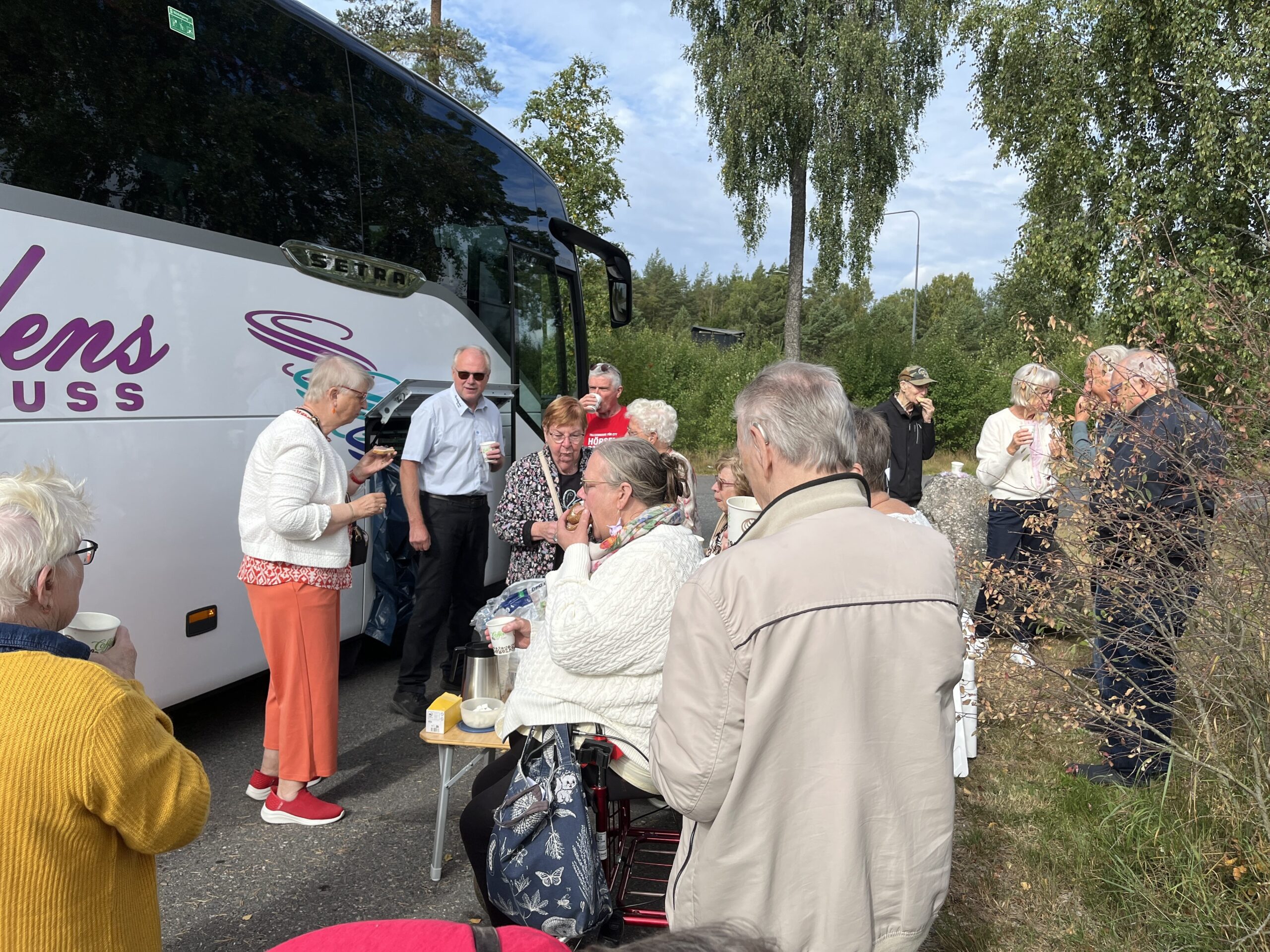 Vi tar en vägkantsfika jämte bussen. Resenärerna dricker kaffe och äter frallor